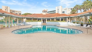 A swimming pool with a tiled deck, lounge chairs, and a covered area with columns. - Z-oceanwalk 2-502 (New Smyrna Beach)
