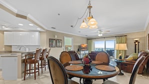 A spacious living room with a round dining table, comfortable seating, and a view of the outdoors. - Z-oceanwalk 2-502 (New Smyrna Beach)