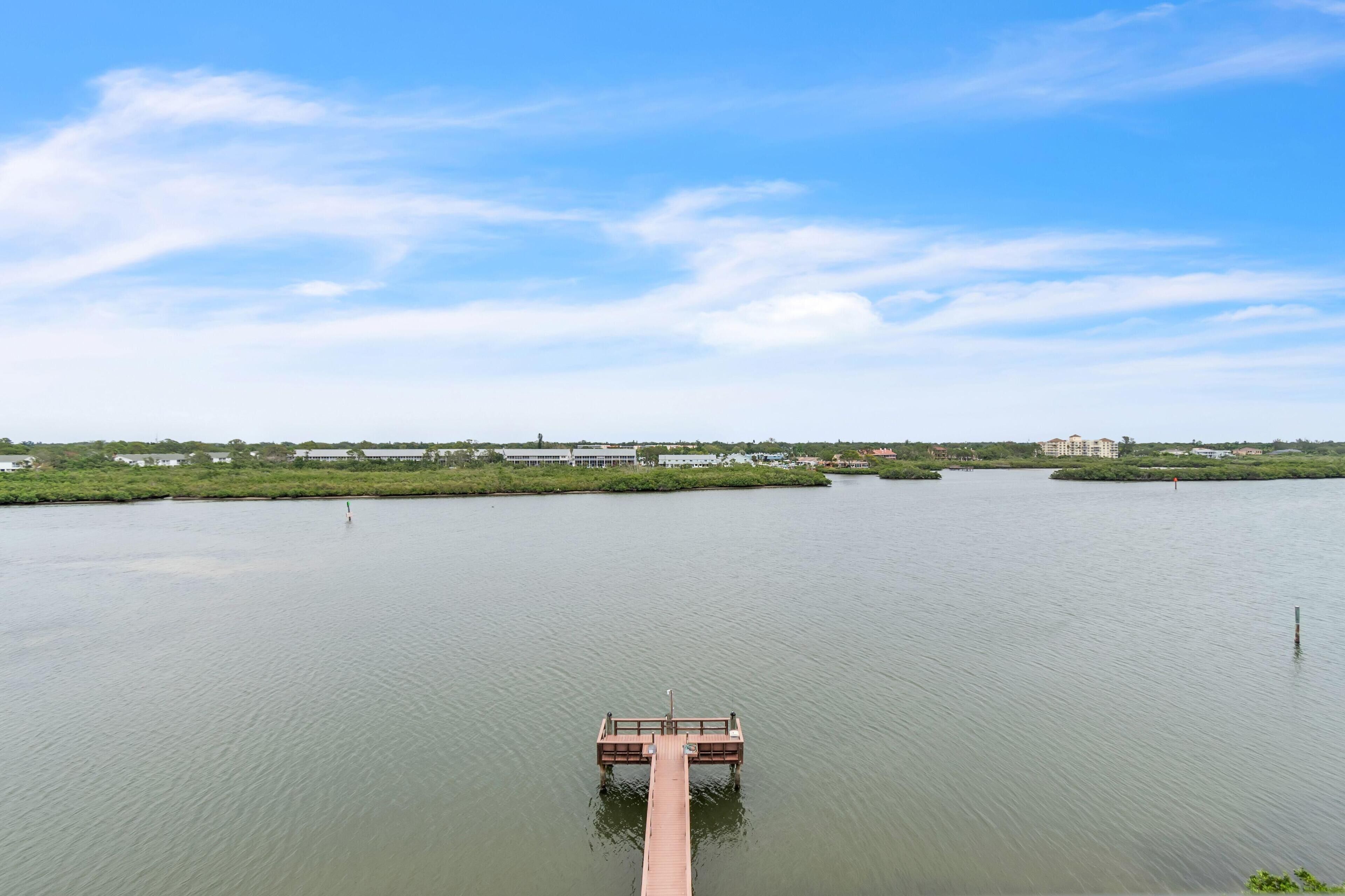 Un muelle de madera que se adentra en aguas tranquilas bajo un cielo despejado.