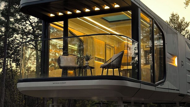 A modern, enclosed space with a glass wall, a dining area with chairs, and a table. - Space Camp (Interlachen)