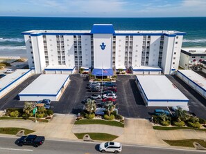 A large hotel with a central entrance, multiple parking lots, and a view of the ocean. - Surfside Club 503 (Daytona Beach Shores)