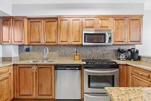Fully equipped kitchen with a microwave, dishwasher, oven, coffee maker, and toaster.