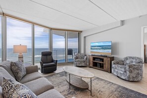 Relax in this ocean-view living room with a sofa set, coffee table, and flat-screen TV.