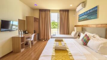 A hotel room with a bed, a desk, a television, and a view of the outdoors.