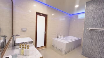 A modern bathroom with a marble vanity, a large bathtub, and a shower area with mosaic tiles.