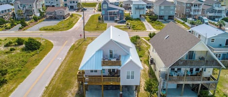 A coastal residential area with houses featuring balconies and a view of the ocean.