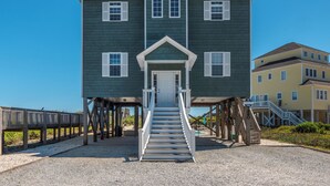 A two-story building with a central entrance and a staircase leading up to it. - Shore Therapy by Topsail Realty (Sneads Ferry)