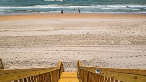 A wooden boardwalk leading to a sandy beach with the ocean in the background. - Hypnautical by Topsail Realty (Holly Ridge)