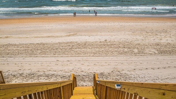 A wooden boardwalk leading to a sandy beach with the ocean in the background. - Hypnautical by Topsail Realty (Holly Ridge)