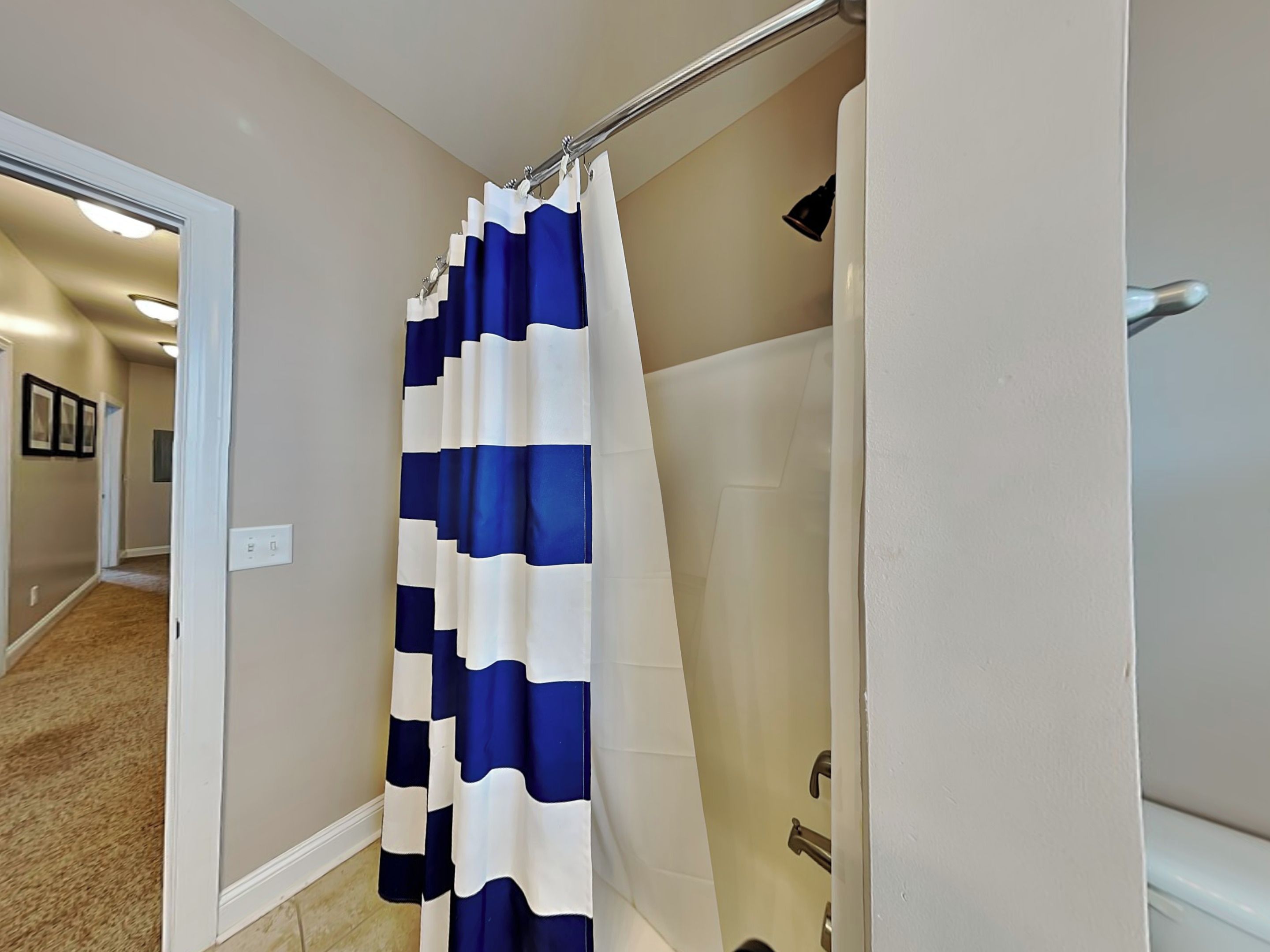 A bathroom with a shower curtain featuring a blue and white pattern.