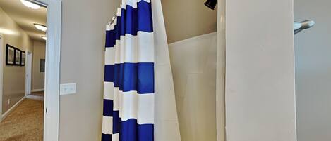 A bathroom with a shower curtain featuring a blue and white pattern.