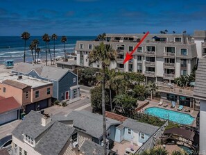 Un hotel frente al mar con varios balcones, piscina y vista al océano.