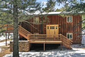 Eine Holzhütte mit einer Holztreppe, die zu einer Terrasse führt.