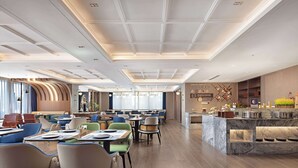 A modern restaurant with a marble bar, multiple seating areas, and a decorative wall. - Hilton Garden Inn Leshan Shizhong (Leshan)