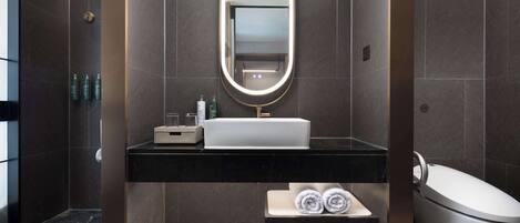 Un baño moderno con un espejo grande, un lavabo, tocador, perchero y zona de ducha.
