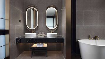 Un bagno moderno con due lavabi, un mobile lavabo, una panca e una vasca freestanding.