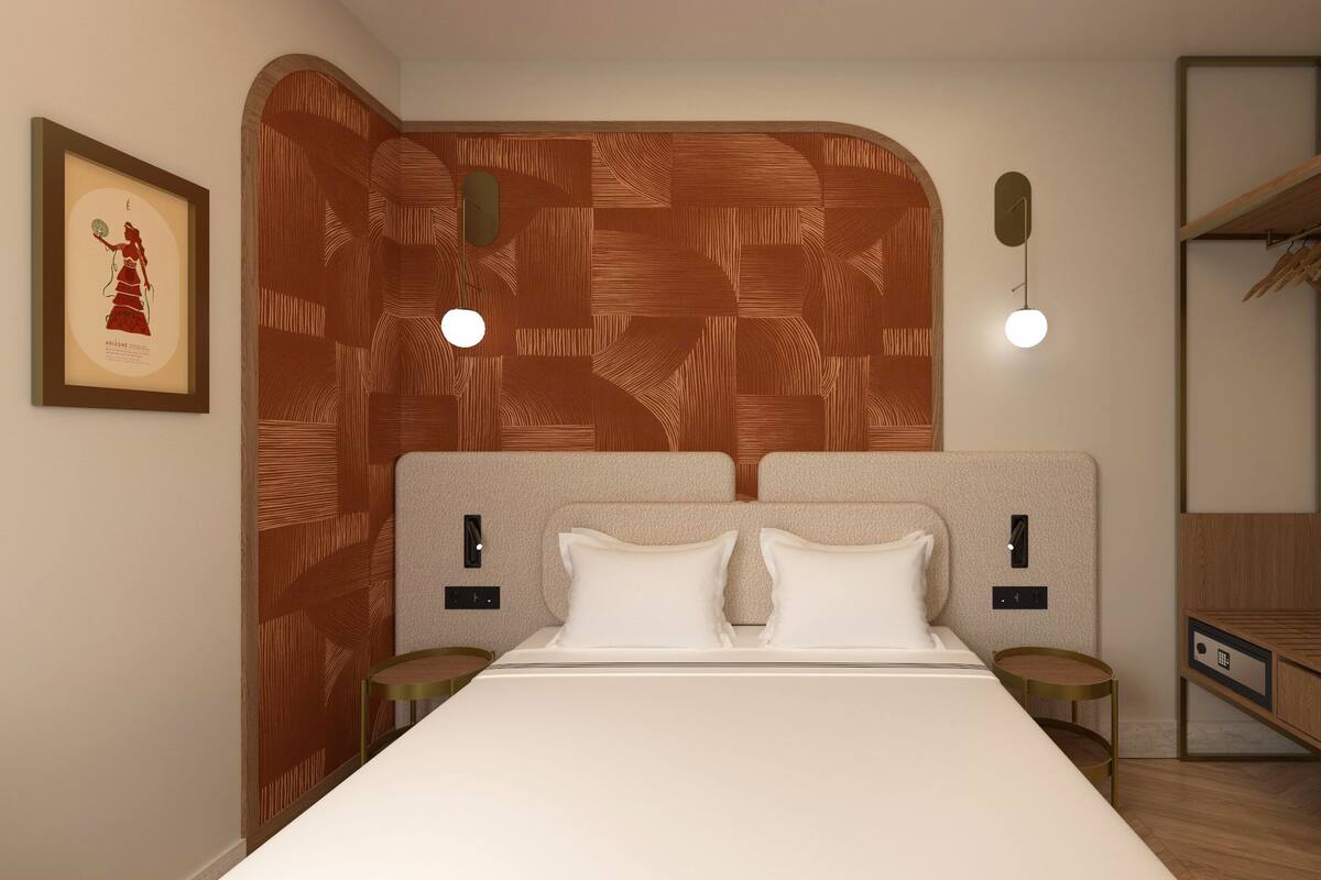 A bedroom with a wooden headboard, a bed with white bedding, two bedside tables, and a hanging light fixture.