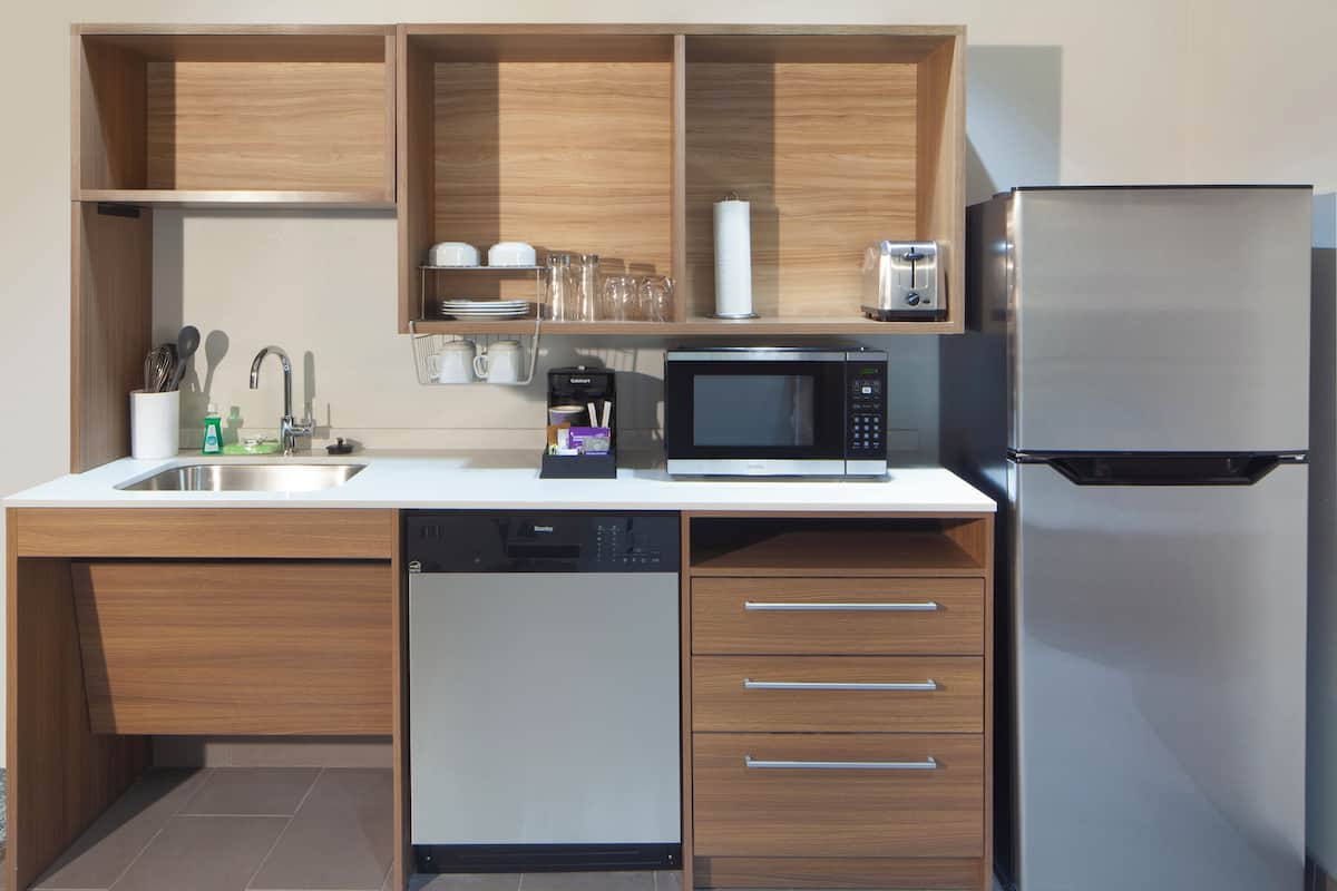 Una cocina moderna con lavavajillas, microondas y refrigerador.