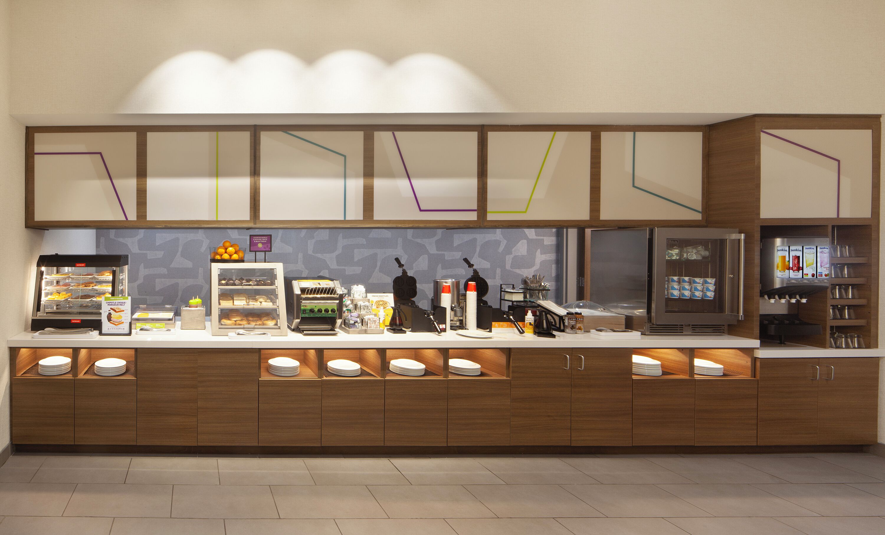 Un buffet-repas moderne en libre-service, proposant une variété d’aliments, une machine à café et un réfrigérateur.