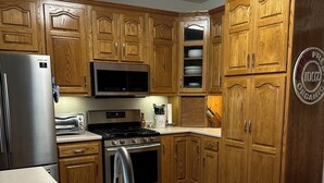 Eine Küche mit Holzausstattung, Edelstahlgeräten und einem Edelstahlspülbecken.
