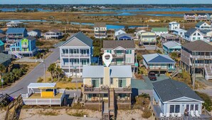Un quartier résidentiel situé sur la côte, où les maisons sont dotées de balcons et offrent une vue sur le littoral.