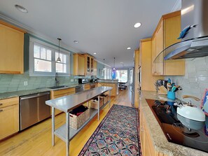 A modern kitchen with wooden cabinets, stainless steel appliances, and a central island.