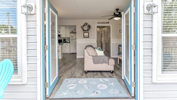 A home interior with a living room, kitchen, and dining area. - Just Beachy Spartanburg by Carolina Retreats (Carolina Beach)
