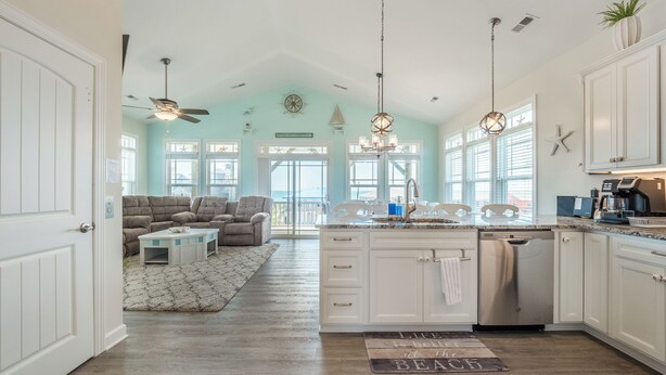 Cocina amplia con una isla central, armarios blancos y vistas al exterior.
