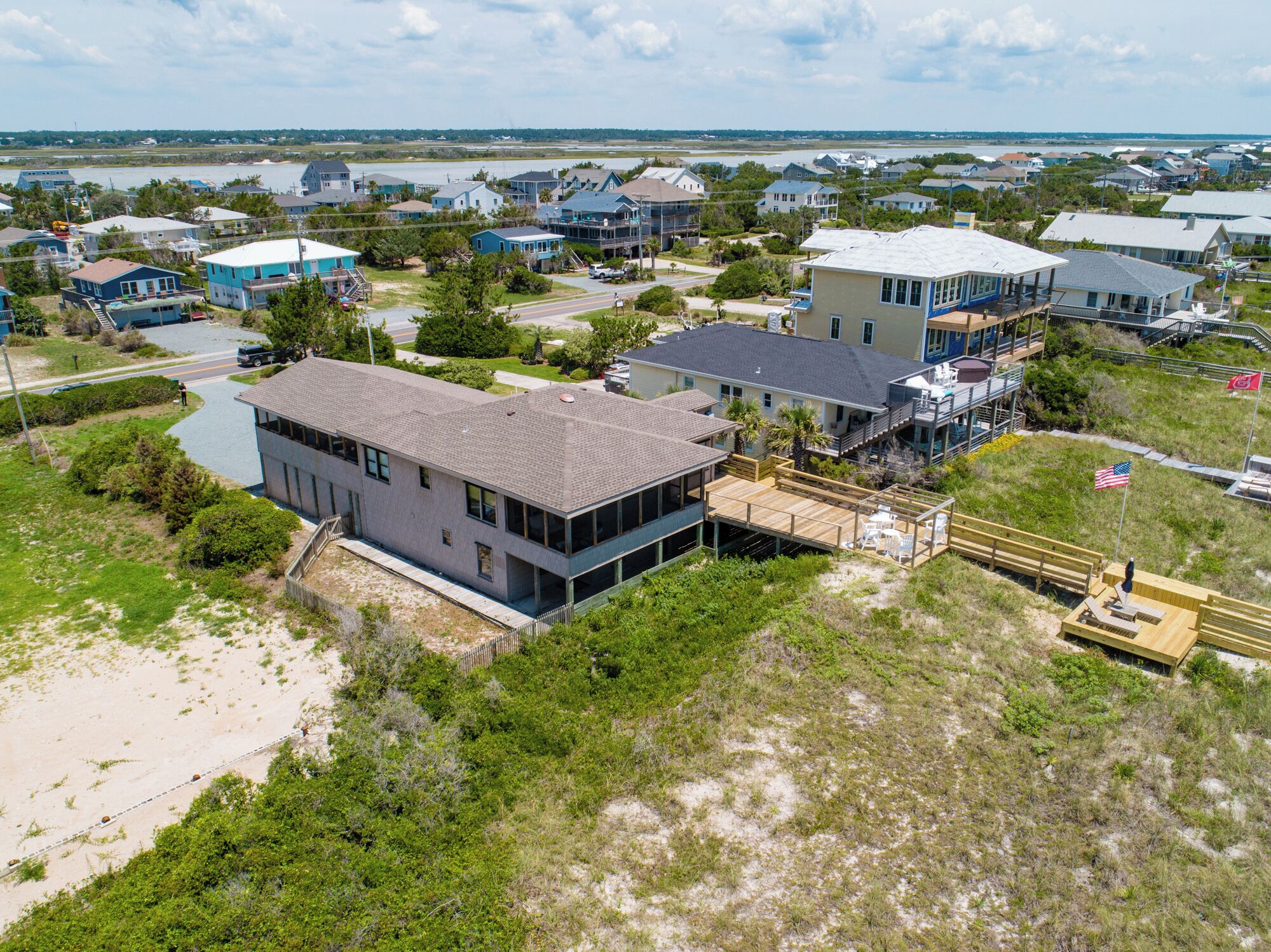A coastal residential area with houses, a beach, and a boardwalk.
