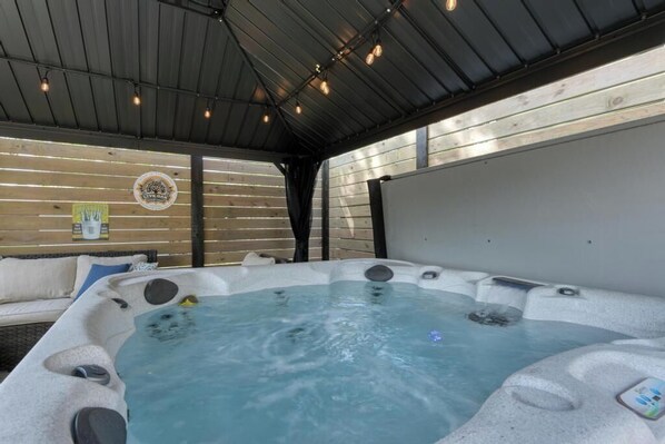 Ein Whirlpool mit Holzterrasse und Metallveranda.
