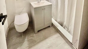 Un baño pequeño con inodoro, lavamanos y cortina de ducha.