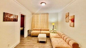 Amplia sala de estar con un conjunto de sofás, una mesa de centro y una lámpara.