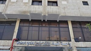 A building with a sign for 'Wahat Quba Serviced Apartment' in English and Arabic. - Wahat Al Madinah Hotel Apartments (Madinah)