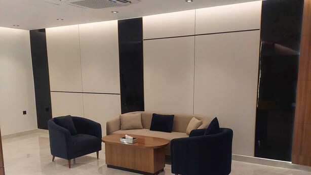A modern lounge area with a sofa set, two armchairs, and a coffee table. - Wahat Al Madinah Hotel Apartments (Madinah)