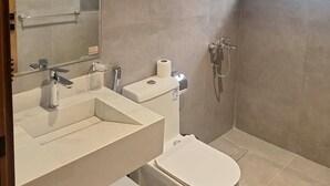 A modern bathroom with a toilet, bidet, and a large mirror. - Wahat Al Madinah Hotel Apartments (Madinah)