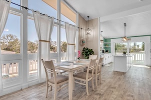 Una cocina amplia con comedor, ventanas grandes y vistas al exterior.