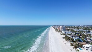 A beachside hotel with a long sandy beach, ocean view, and a pool area. - Bates Avenue House (Indian Rocks Beach)