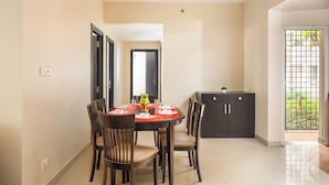 A dining area with a round table, chairs, and a ceiling fan. - Aspire Heights by Red Olive (Bengaluru)