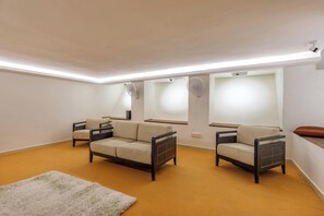 A modern living room with two sofas, a white rug, and a wooden floor.