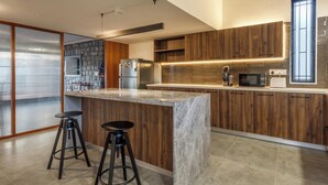 Una cocina moderna con una isla central, armarios de madera y una salpicadera de piedra.