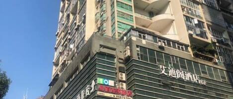 A multi-story building with balconies and signage.