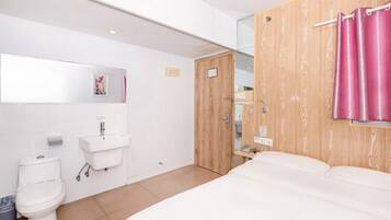 A modern bathroom with a toilet, sink, and shower area.