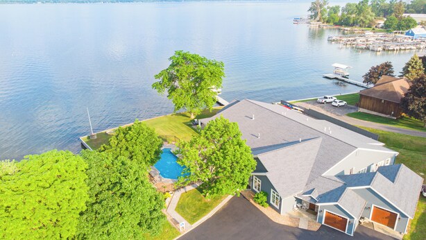 Um imóvel residencial com piscina, garagem e um cais à beira da água.