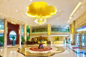 A spacious lobby with a central decorative fountain, a high ceiling with a large chandelier, and a reception desk. - Yushan Hotel (Changshu)