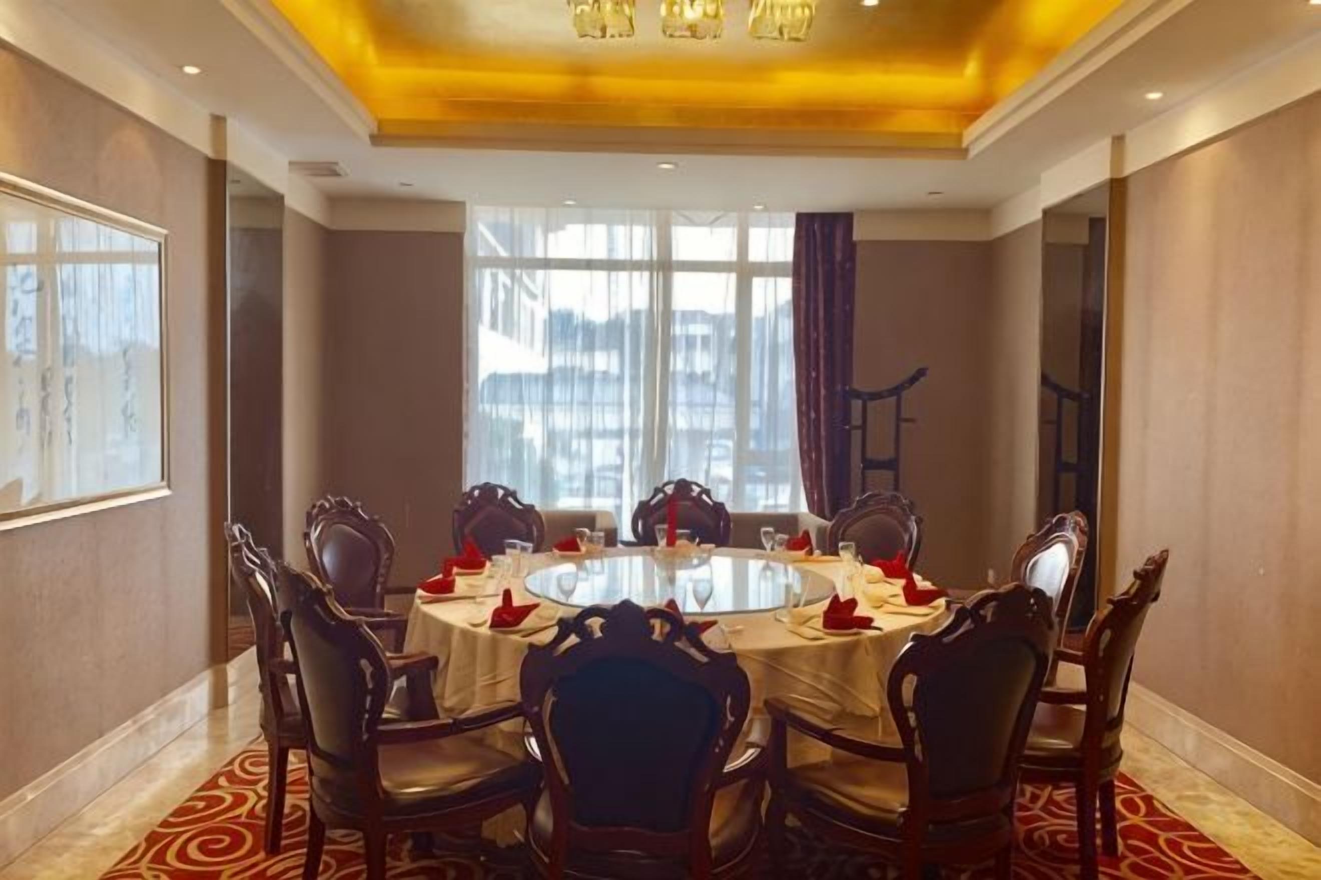 A conference room with a round table, chairs, and a large window.