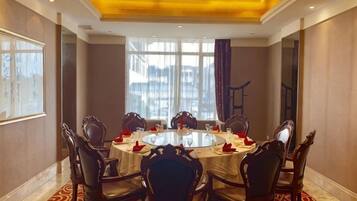 A conference room with a round table, chairs, and a large window.