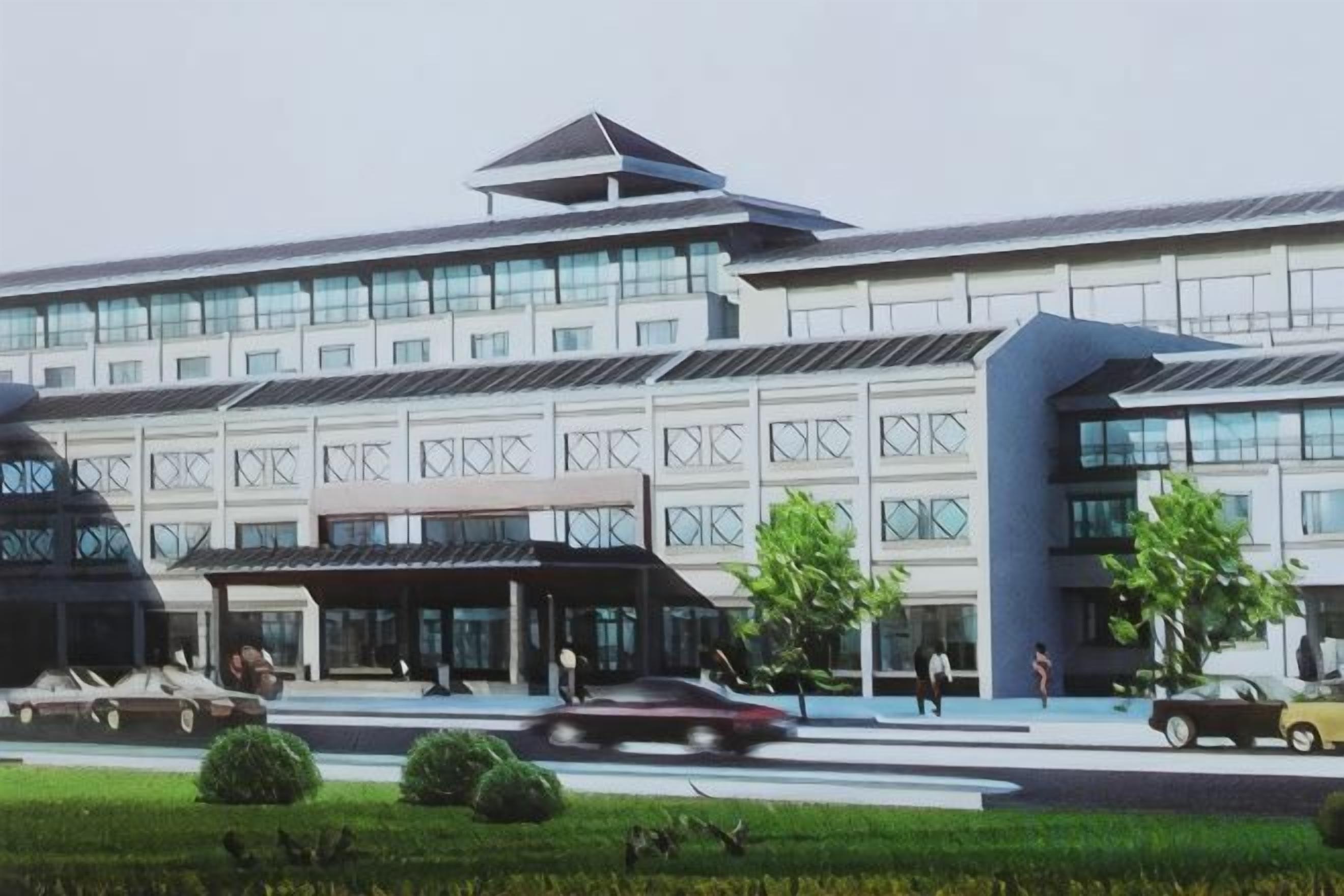 A modern building with a flat roof, large windows, and a covered entrance area.