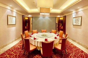 A conference room with a round table, chairs, and a carpeted floor. - Yushan Hotel (Changshu)