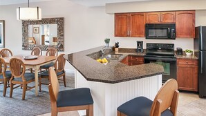 A modern kitchen with granite countertops, wooden cabinets, and stainless steel appliances. - Sheraton Broadway Plantation/2BR-2BA/Labor Day Weekend 08/29 - 09/01 (Myrtle Beach)
