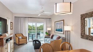 A hotel room with a dining area, a sofa, a TV, and a balcony with a view of greenery. - Sheraton Broadway Plantation/2BR-2BA/Labor Day Weekend 08/29 - 09/01 (Myrtle Beach)